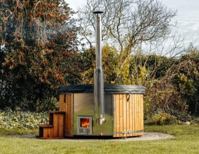Hottub met Thermowood ombouw, kachel en trap in een tuin